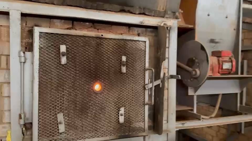 Forno em operação, com a chama visível pela grade
